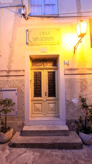 A building entrance with a double door, a sign above reading "CASA SAN GIOVANNI", and a street lamp to the right. - Holiday apartment with air conditioning, right in the old town (Lovran)