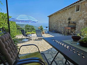 Relax on the patio with a scenic view of the water and distant hills.