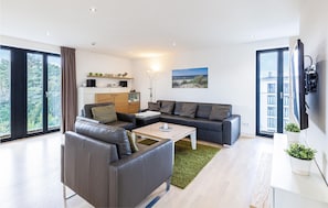 A modern living room with a sofa, a coffee table, and a TV.