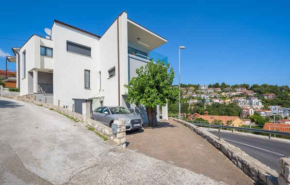 A modern two-story building with a car parked in front. - 2 bedroom beautiful apartment in Rabac (Rabac)