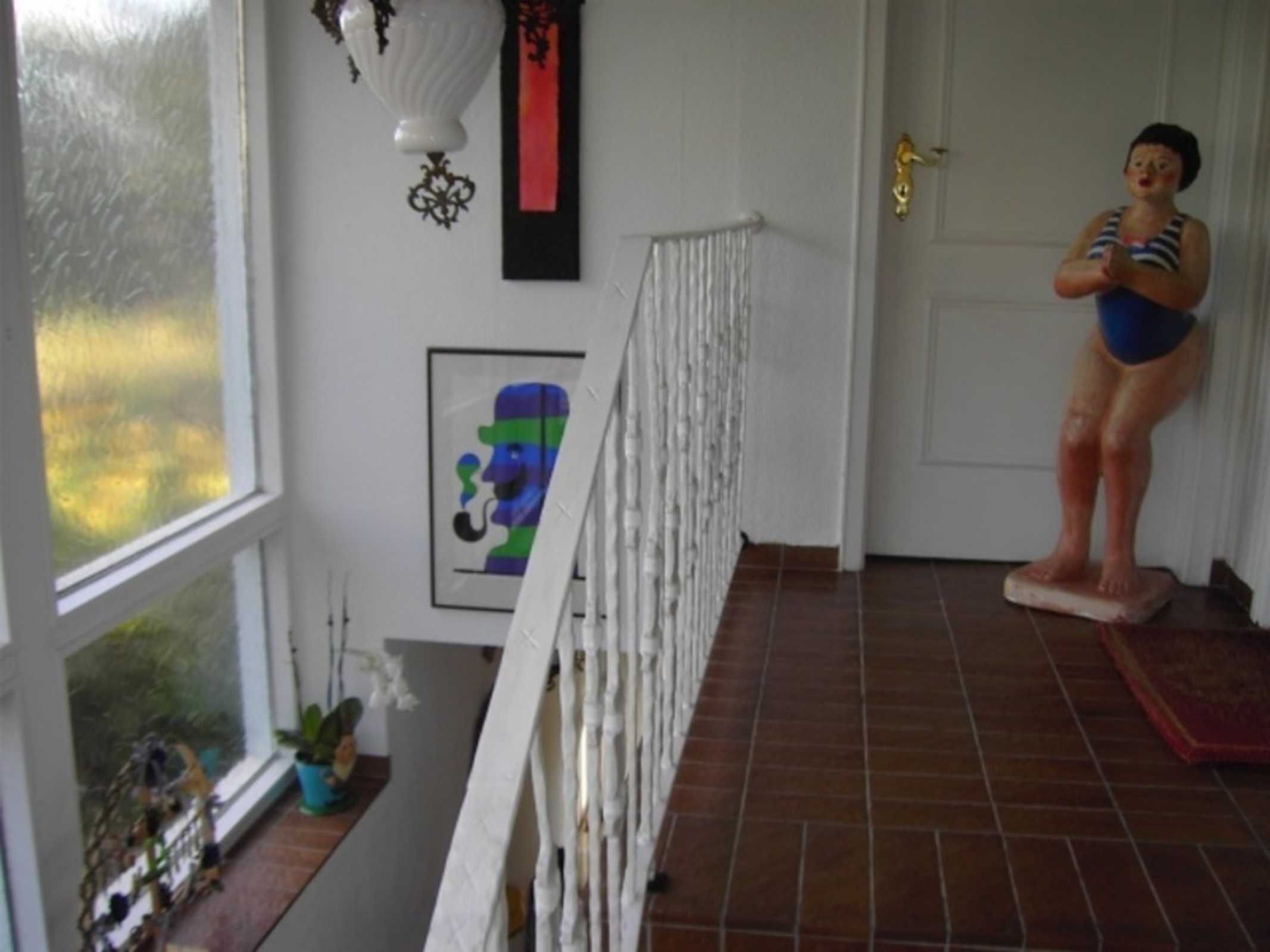 Una habitación con barandilla blanca, una puerta y una ventana.