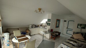 A compact living space with a dining area, kitchenette, and a sofa. - 1-room apartment 1, 30 m² - Graf Luckner Hüs (Scharbeutz)