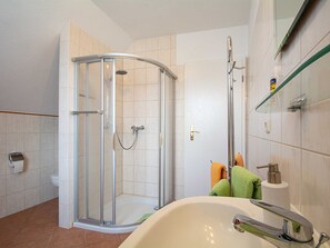 A bathroom with a glass-enclosed shower, a bathtub, and a toilet.