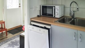 A compact kitchen with a microwave, dishwasher, and sink.