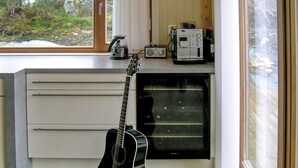 Een keuken met een gitaar, een koffiezetapparaat en een magnetron.