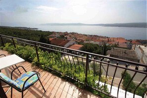 A balcony with a view of a coastal town and a large body of water. - Holiday apartment with balcony and air conditioning (Crikvenica)