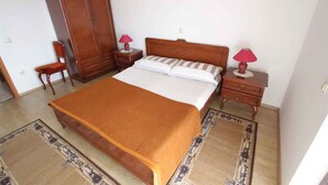 Ein Schlafzimmer mit einem großen Bett, zwei Nachttischen mit Lampen, einem Kleiderschrank und einem Teppich.