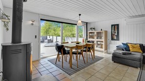 Een moderne woonkamer met een eethoek, een open haard en uitzicht op de omgeving.