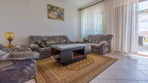 A living room with patterned sofas, a coffee table, a lamp, and a rug. - Holiday apartment with air conditioning and WLAN (Crikvenica)
