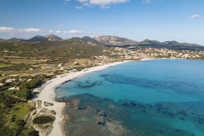 An aerial view of a coastal town with a beach, clear blue waters, and surrounding mountains. - Holiday apartment mit Veranda (Pittulongu)