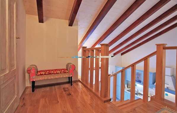 A wooden staircase with a bench in a hallway.