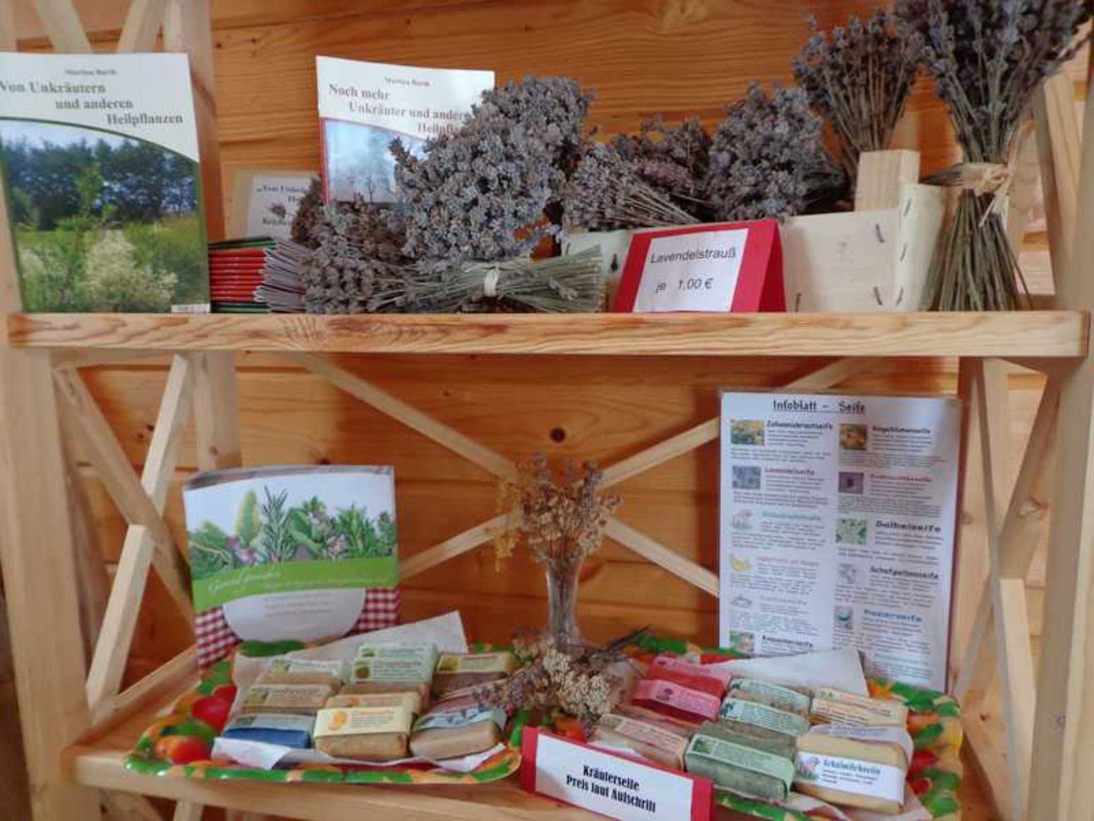 A wooden shelf with books, dried lavender, and packaged food items.