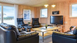 A cozy cabin interior with wooden walls, a large TV, leather sofas, and a dining table. - 3 bedroom stunning home in Harboøre (Harboøre)
