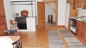 A kitchen with wooden cabinets, a stove, a refrigerator, and a rustic rug. - 3 bedroom nice home in Tranås (Tranås)