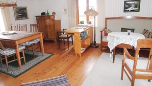 A cozy, well-lit room with a wooden dining table, chairs, a bookshelf, and a small round table with a white lace tablecloth. - 3 bedroom nice home in Tranås (Tranås)