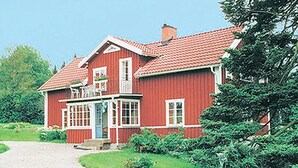 A red wooden house with a tiled roof, a porch, and a gravel driveway. - 3 bedroom nice home in Tranås (Tranås)
