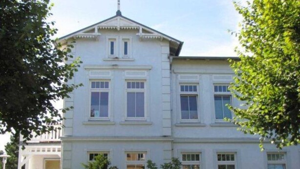 A two-story building with a symmetrical facade, multiple windows, and a central entrance. - (171) 3- room apartment - apartment house Strandstr. 16 (Kühlungsborn)