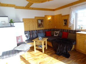 A cozy room with a wooden bench, a table, and a sofa with cushions.