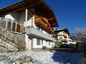 A multi-story building with balconies, a wooden facade, and a snow-covered ground. - Apartment for 6 persons Deluxe - Alpine jewel (Laimach)