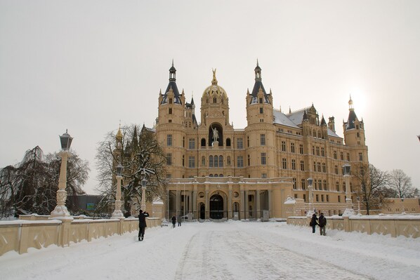 Un grand bâtiment imposant, richement décoré, doté de plusieurs tours et d’une entrée centrale.