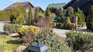 Et boligområde med flere huse, en asfalteret indkørsel og forskelligt vegetation.