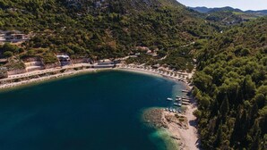 An aerial view of a coastal area with a beach, boats, and buildings surrounded by dense forest. - Nice home in Kremena with sauna (Kremena)