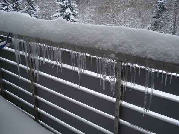 A metal railing with icicles hanging from it.