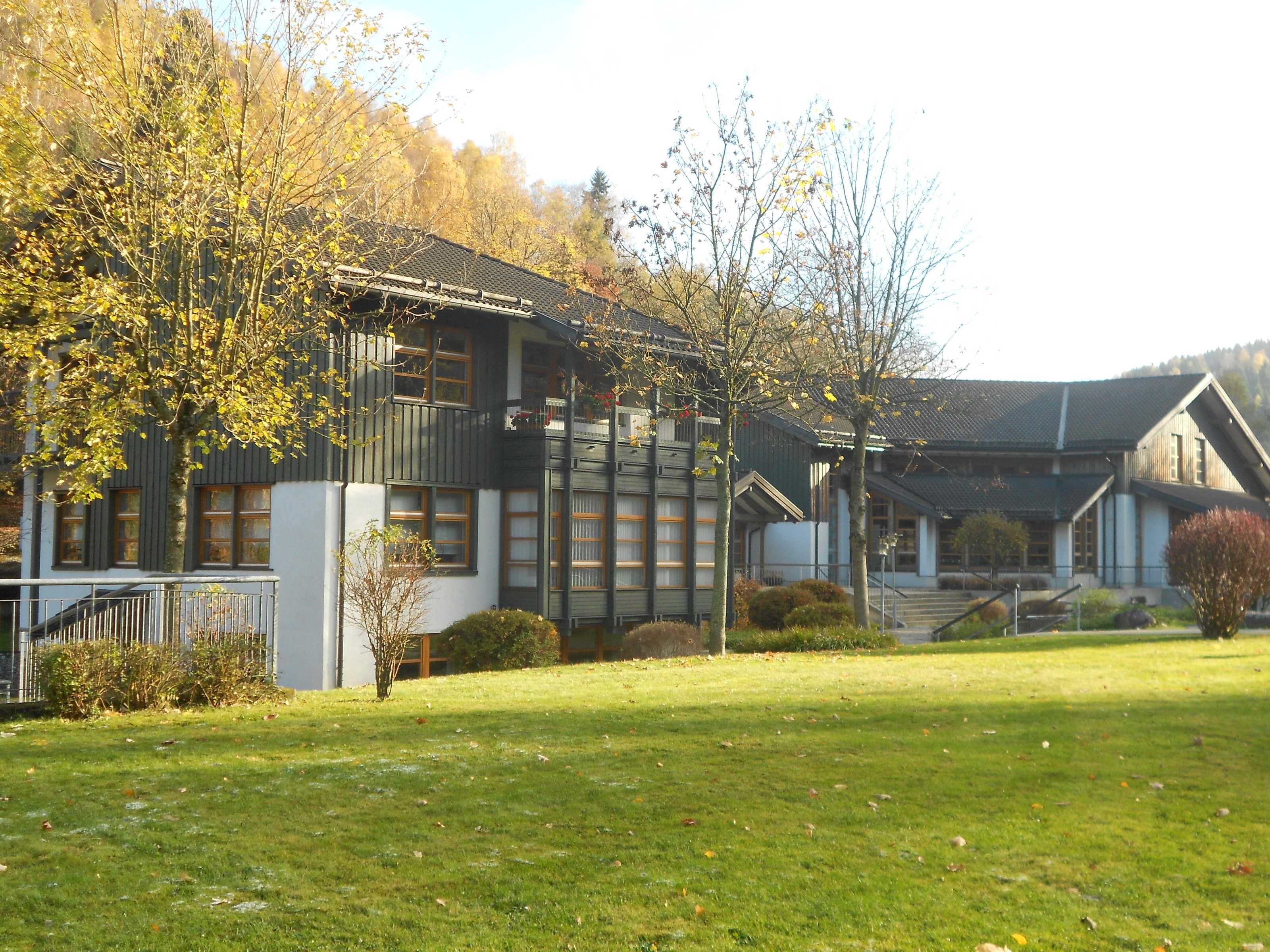 A building with multiple windows, a balcony, and a staircase leading to the entrance.