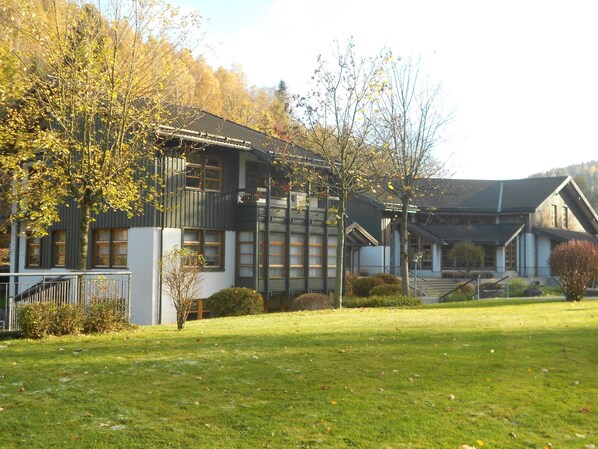 A building with multiple windows, a balcony, and a staircase leading to the entrance.