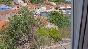 A coastal town with buildings, a marina, and a hilltop view. - Holiday apartment with terrace (Veli Lošinj)
