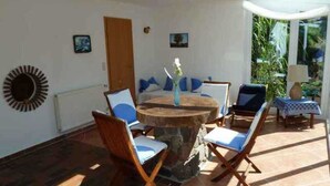 A sunlit patio with a round table, chairs, and a small table with a lamp. - Schiel apartment rental - Apartment (Zempin)