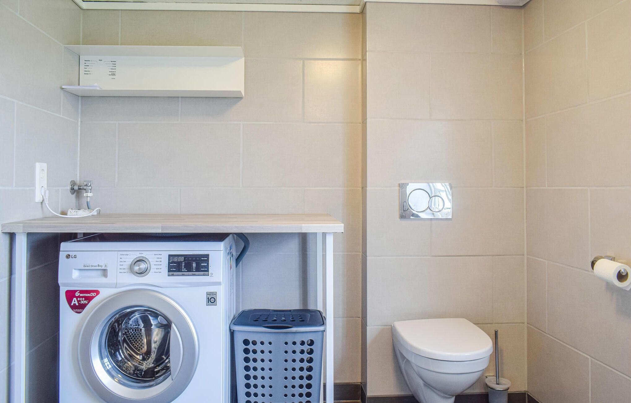 A compact laundry area with a washing machine, a dryer, and a toilet.