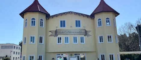 En tvåvåningsbyggnad med en skylt som visar texten ”Hotel Dimenschloss”.