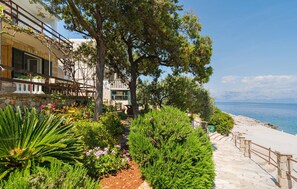 A coastal hotel with a stone facade, a balcony with outdoor seating, and a view of the sea. - Stunning home in Zastrazisce with house sea view (Zastrazisce)