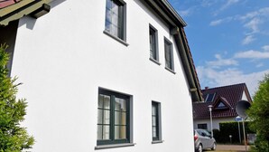 A white building with three windows and a satellite dish. - Apartment with Balcony - Ferienhaus Alt-Baabe (Baabe)