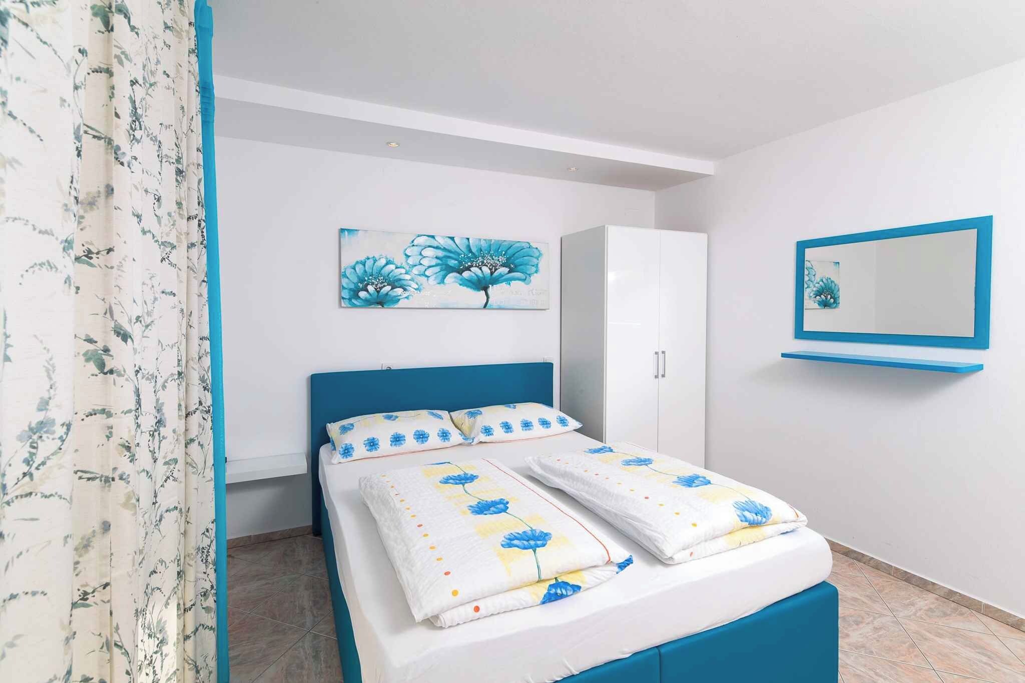Un dormitorio con cama, armario, espejo y cortina con estampado floral.