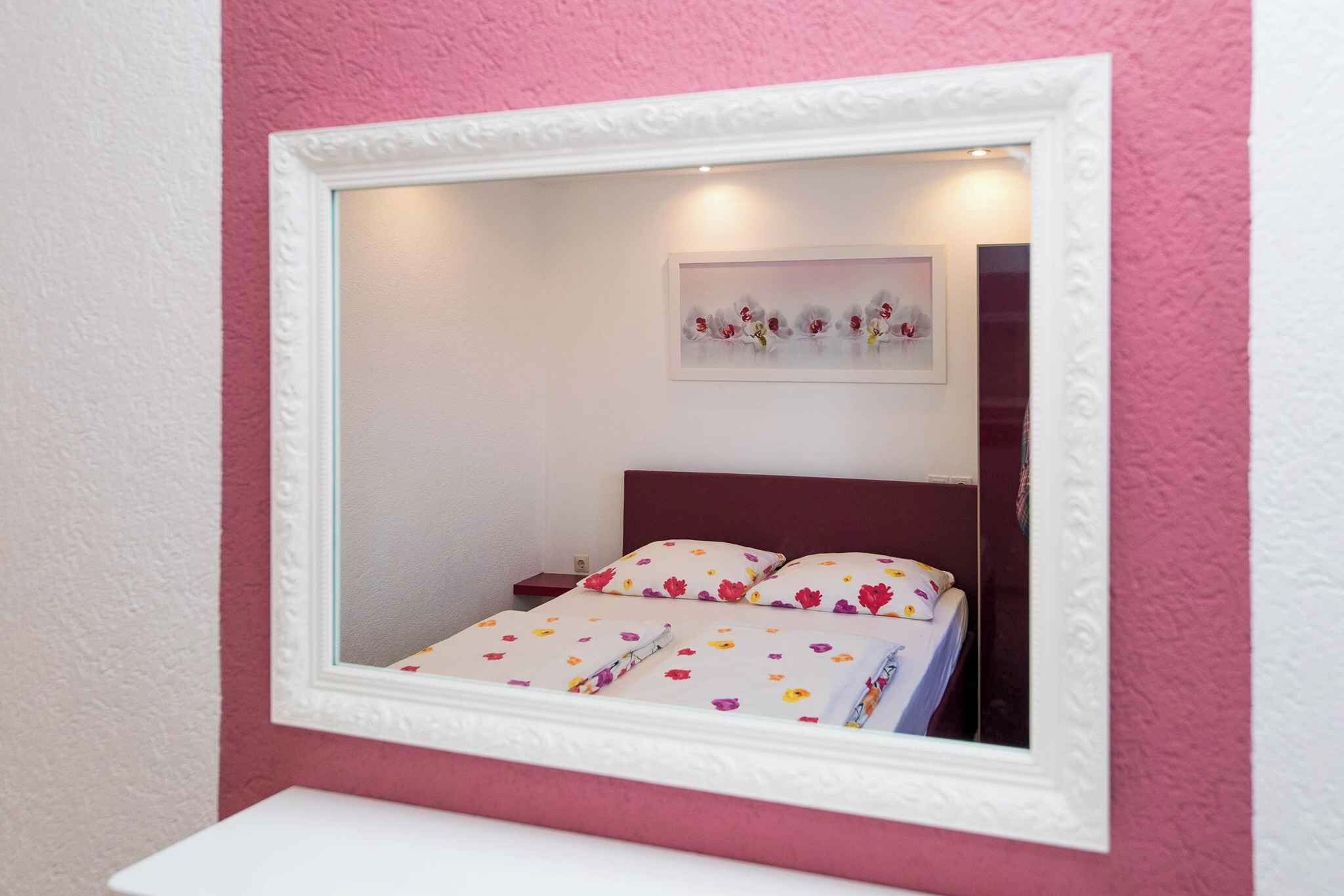 Ein Schlafzimmer mit einem Bett, einem Nachttisch und einem Spiegel.
