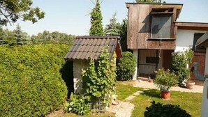 Una casa con un jardín pequeño, un sendero y un edificio moderno con techo inclinado.