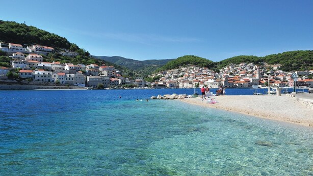 A coastal town with clear blue waters, a sandy beach, and buildings with red roofs. - Amazing home in Pucisca (Pucisca)