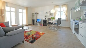 Ein modernes Apartment mit Wohnzimmer, Essbereich und Küche.