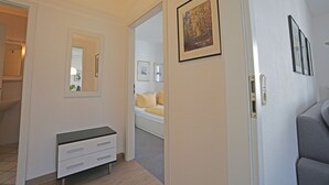 Ein Hotelzimmer mit Bett, Nachttisch, Spiegel und einem gerahmten Bild an der Wand.
