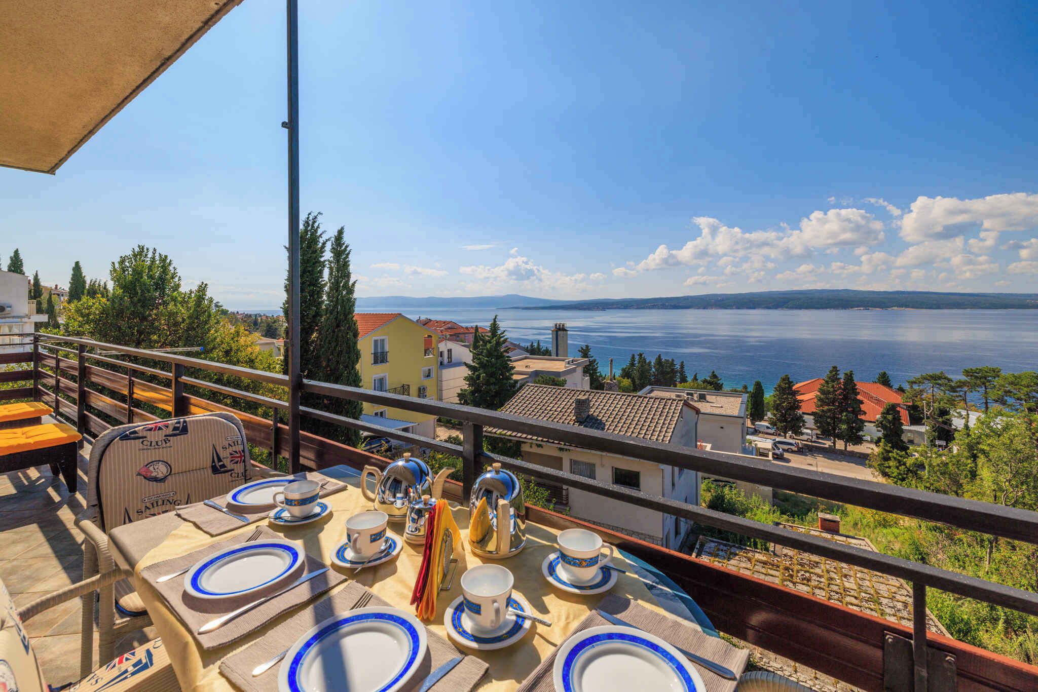 A table set for four with a view of the sea and buildings in the background.