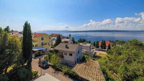 Un área residencial costera con casas, vistas despejadas al mar y un cielo soleado.