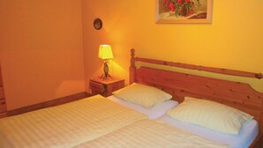 Un lit double avec deux oreillers, une table de chevet avec une lampe et un tableau au mur.