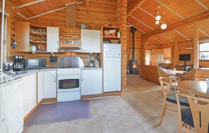 A wooden cabin interior with a kitchen, dining area, and a fireplace. - Cozy home in Vinderup with sauna (Vinderup)