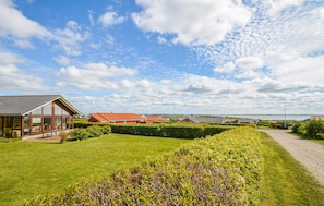 A residential area with houses, a well-maintained lawn, and a clear sky. - Cozy home in Vinderup with sauna (Vinderup)