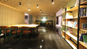 Una biblioteca con estanterías de madera, mesas y sillas.