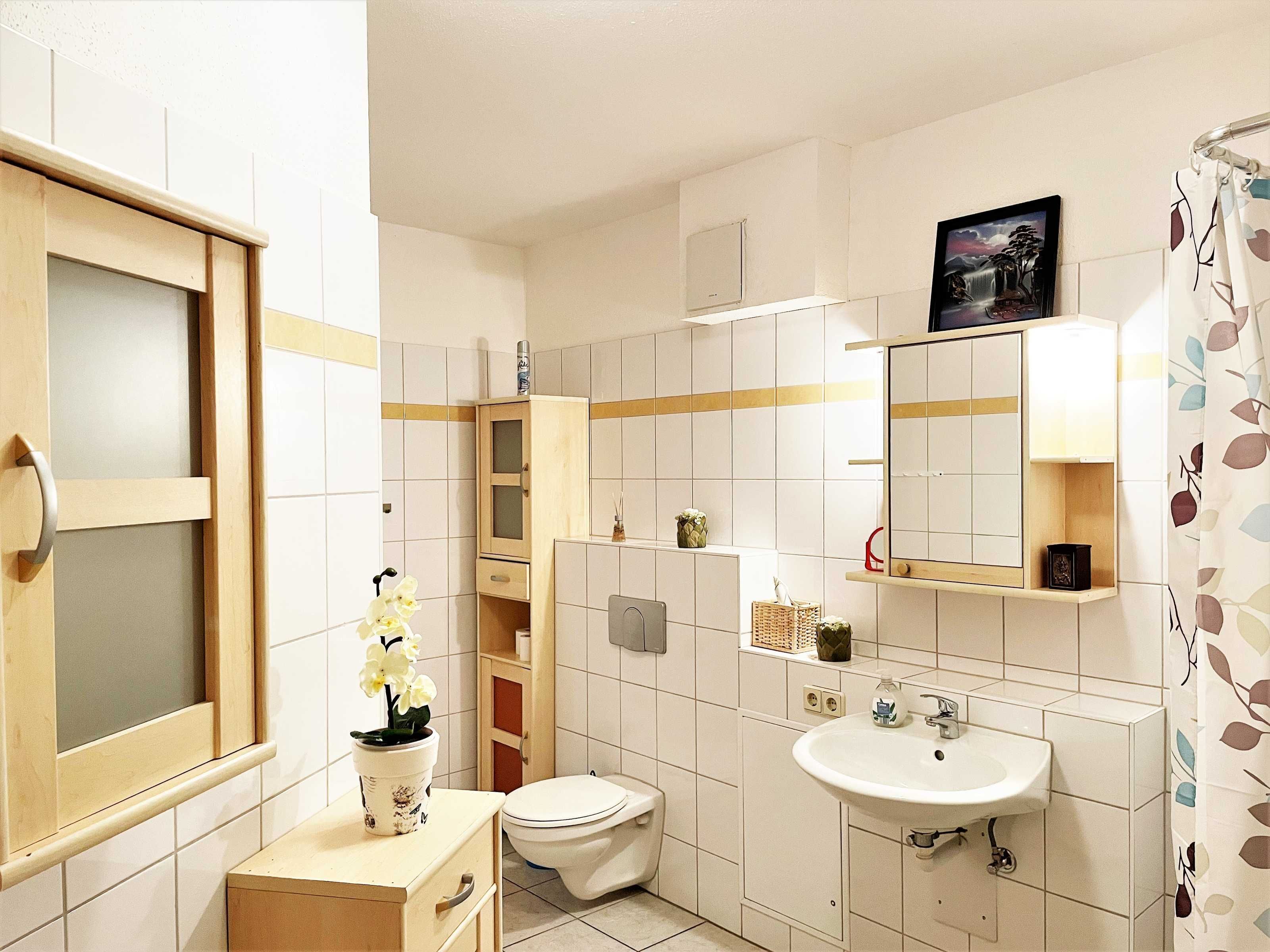 A bathroom with a toilet, sink, and cabinet.