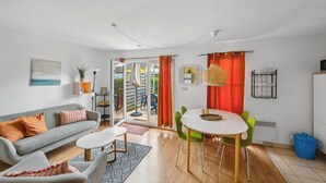 Una sala de estar moderna con un sofá, una mesa de centro y un comedor con sillas.