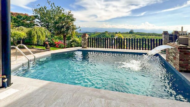 A swimming pool with clear water, surrounded by a stone wall and a wooden fence. - 3 bedroom cozy home in Marsaglia CN (Marsaglia CN)